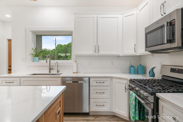 1200 Iroquois Trl, Hastings, MI 49058 - kitchen with appliances with stainless steel finishes, a sink, white cabinetry, and light countertops