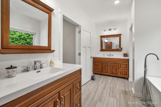 1200 Iroquois Trl, Hastings, MI 49058 - full bathroom featuring two vanities, a soaking tub, and recessed lighting