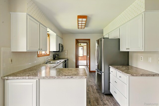 321 Myers Rd, Lapeer, MI 48446 - kitchen featuring stainless steel appliances, wallpapered walls, dark wood-type flooring, a sink, and white cabinetry