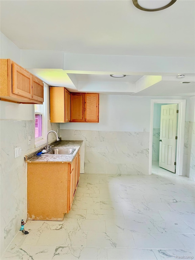 2995 Alvina Ave, Warren, MI 48091 - kitchen featuring a sink, tile walls, light marble finish flooring, brown cabinetry, and light countertops