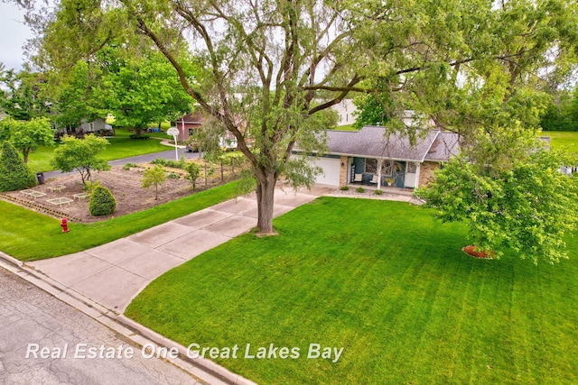 4936 Frontier Ln, Saginaw, MI 48603 - view of front facade with a front yard, driveway, a porch, and a garage