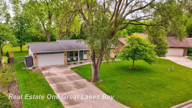 4936 Frontier Ln, Saginaw, MI 48603 - view of front facade with a porch, brick siding, driveway, a front yard, and a garage
