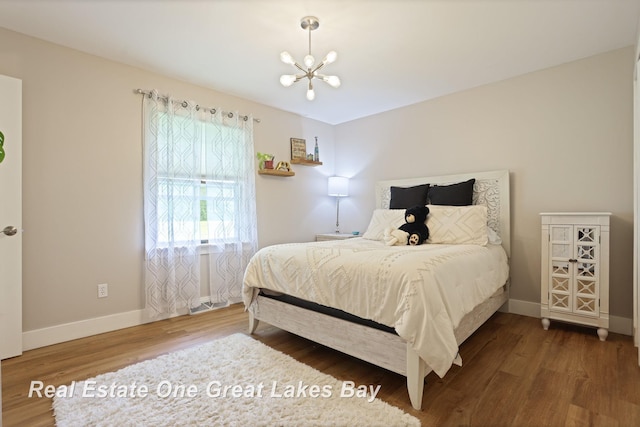4936 Frontier Ln, Saginaw, MI 48603 - bedroom with a chandelier, wood finished floors, and baseboards