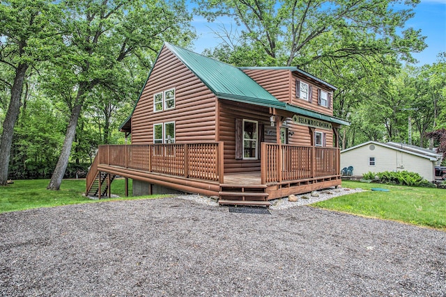 283 S Fremont Rd, Coldwater, MI 49036 - chalet / cabin featuring log veneer siding, a front yard, metal roof, and a wooden deck