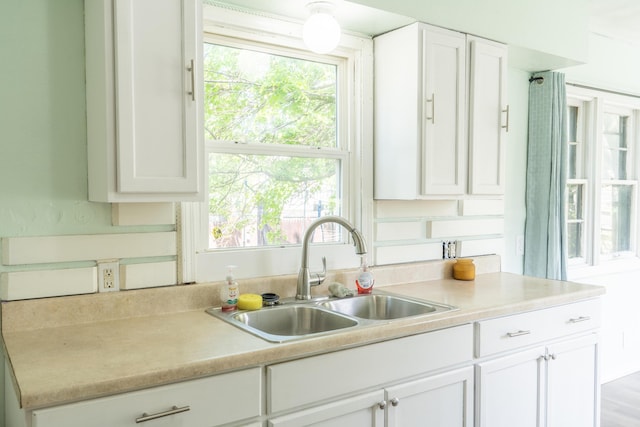 428 Orchard Ave, Muskegon, MI 49442 - kitchen with a sink, white cabinetry, light countertops, and plenty of natural light