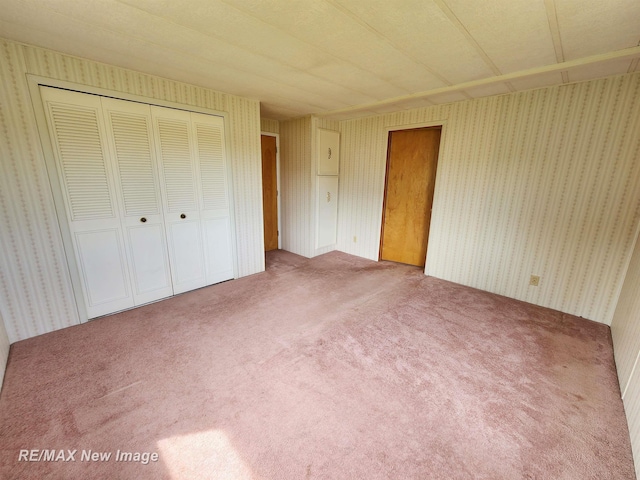 10424 S Graham Rd, Saint Charles, MI 48655 - unfurnished bedroom with wallpapered walls, carpet floors, and a closet