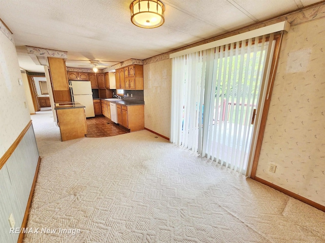 10424 S Graham Rd, Saint Charles, MI 48655 - kitchen with white appliances, a sink, wallpapered walls, dark countertops, and carpet floors