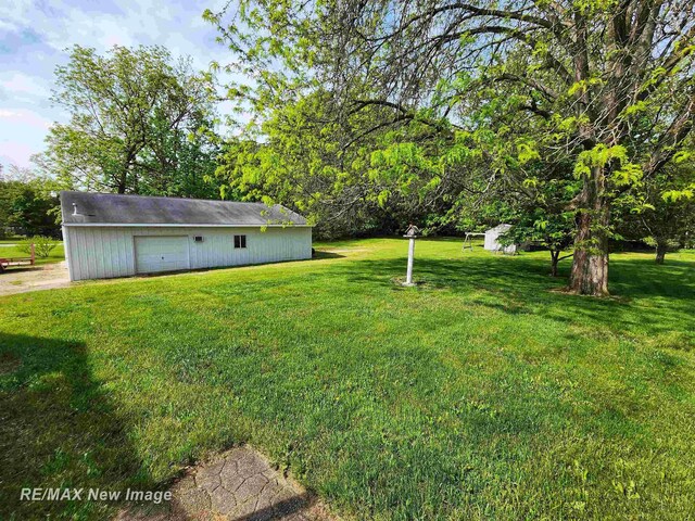 10424 S Graham Rd, Saint Charles, MI 48655 - view of green lawn featuring a detached garage and an outdoor structure