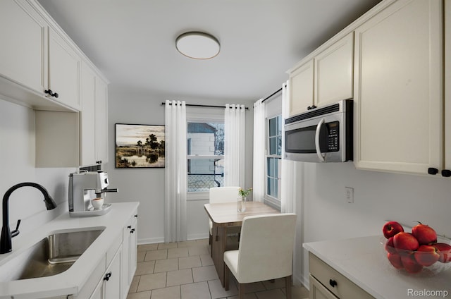 22813 Rosalind Ave, Eastpointe, MI 48021 - kitchen with stainless steel microwave, a sink, light tile patterned floors, and light countertops