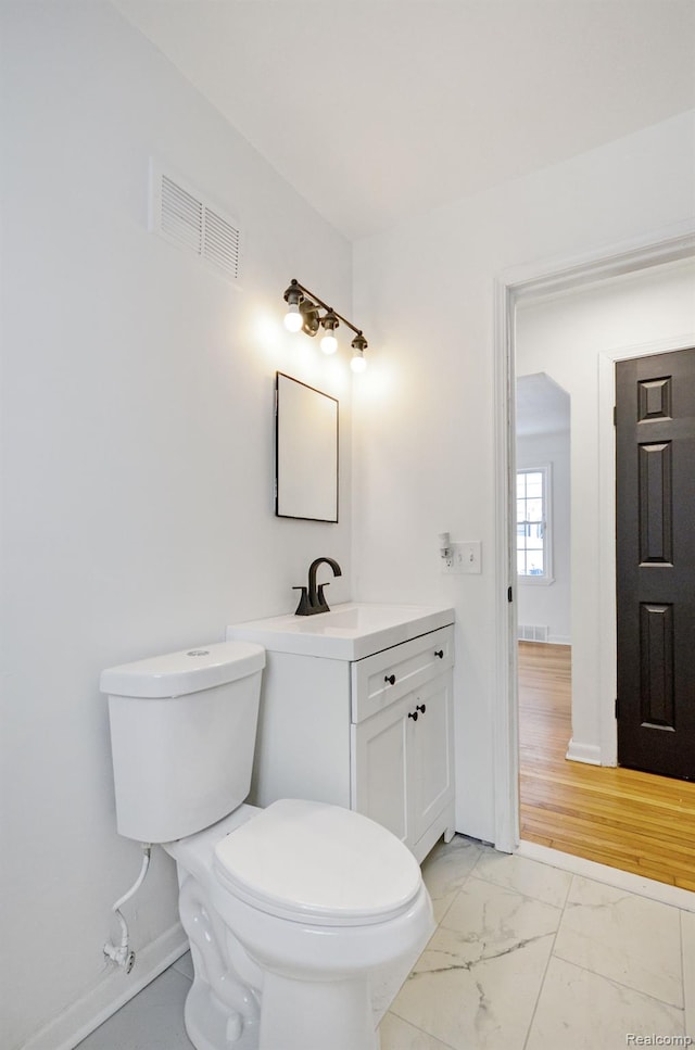22813 Rosalind Ave, Eastpointe, MI 48021 - half bathroom with vanity, marble look tiles, toilet, and baseboards