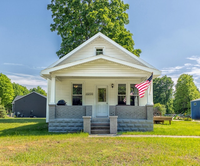 15230 Lincoln St, Grand Haven, MI 49417 - view of front of property featuring covered porch, a front lawn, and stone siding