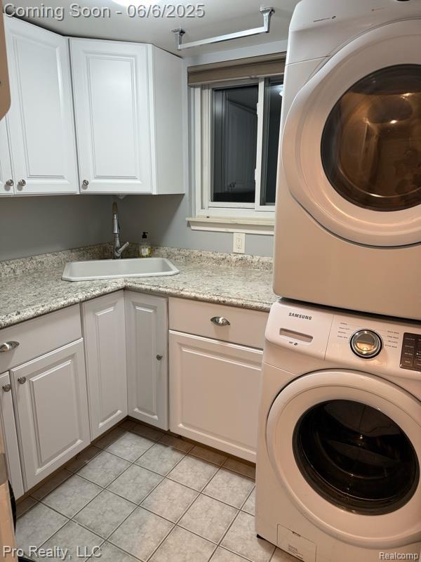 44195 Dartmouth St, Canton, MI 48188 - laundry area featuring stacked washer / drying machine, cabinet space, and light tile patterned floors