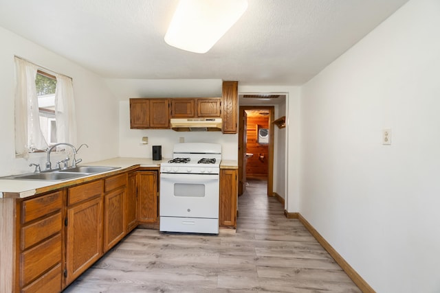 817 Annetta Ave, Jackson, MI 49203 - kitchen with white range with gas cooktop, a sink, light wood-type flooring, and light countertops