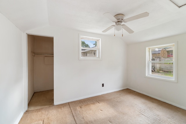 817 Annetta Ave, Jackson, MI 49203 - unfurnished bedroom with light colored carpet, vaulted ceiling, a closet, baseboards, and a walk in closet