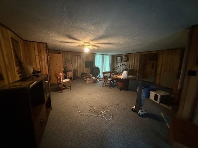 4465 E Old M-63, Luther, MI 49656 - living area featuring wood walls, a textured ceiling, ceiling fan, and carpet