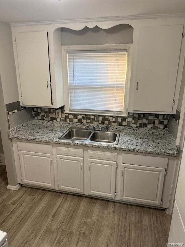 18950 Blackmoor St, Detroit, MI 48234 - kitchen featuring a sink, white cabinetry, wood finished floors, light countertops, and decorative backsplash