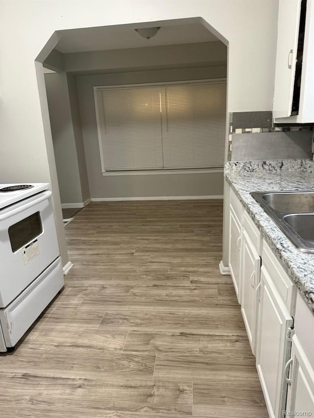 18950 Blackmoor St, Detroit, MI 48234 - kitchen featuring white electric range, white cabinets, baseboards, light wood finished floors, and a sink