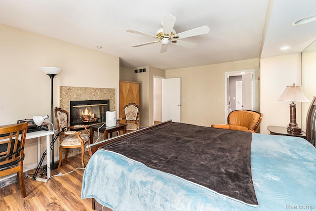 5130 Whitlow Ct, Commerce Twp, MI 48382 - bedroom with wood finished floors, a fireplace, and ceiling fan
