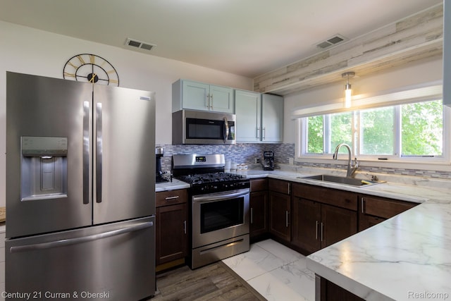 7641 N Inkster Rd, Westland, MI 48185 - kitchen featuring appliances with stainless steel finishes, a sink, decorative backsplash, and light stone countertops