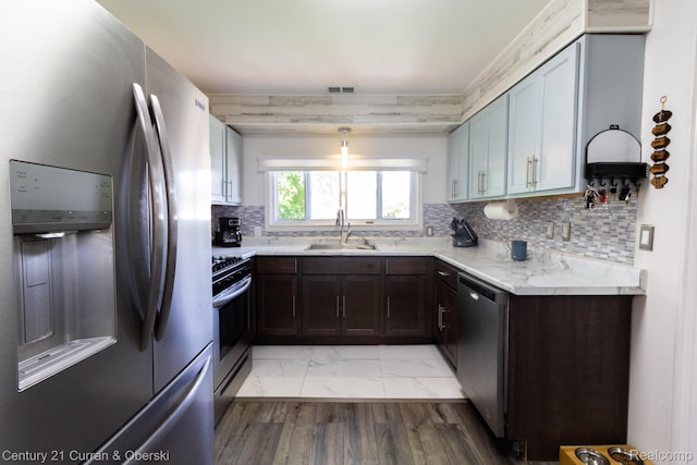7641 N Inkster Rd, Westland, MI 48185 - kitchen with stainless steel appliances, a sink, light marble finish flooring, tasteful backsplash, and dark brown cabinetry