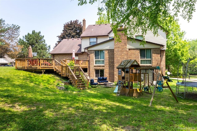 38649 Deerwood Ct, Northville, MI 48167 - back of property with a trampoline, a playground, brick siding, and a deck
