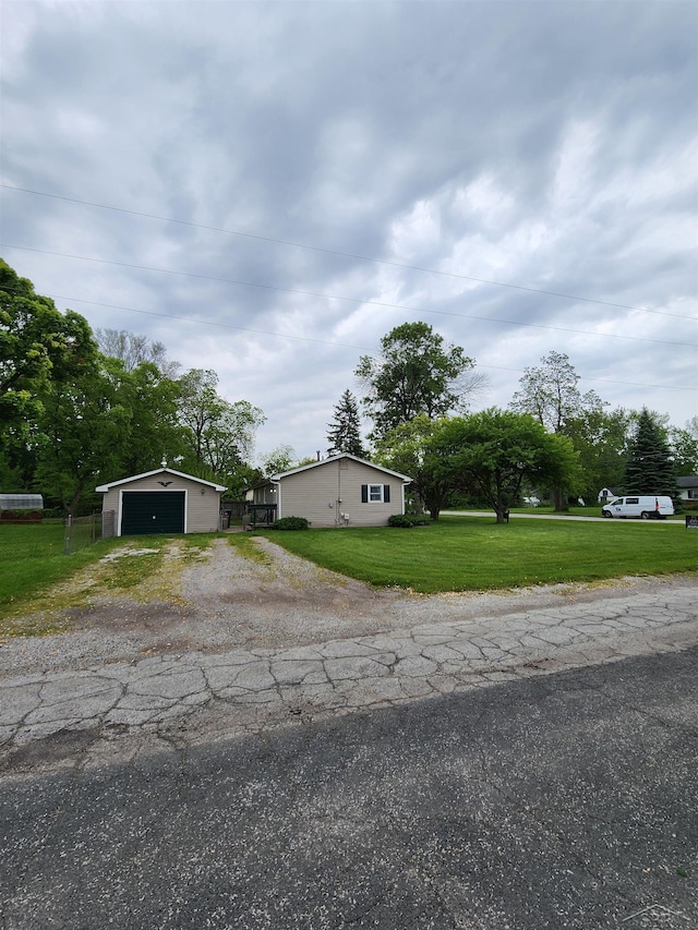 2285 Nebraska Ave, Saginaw, MI 48601 - view of front of house with an outdoor structure, a detached garage, a front yard, and driveway
