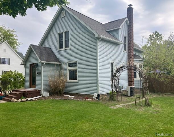 161 Fourth, Harbor Beach, MI 48441 - back of house featuring a chimney, a lawn, and central AC