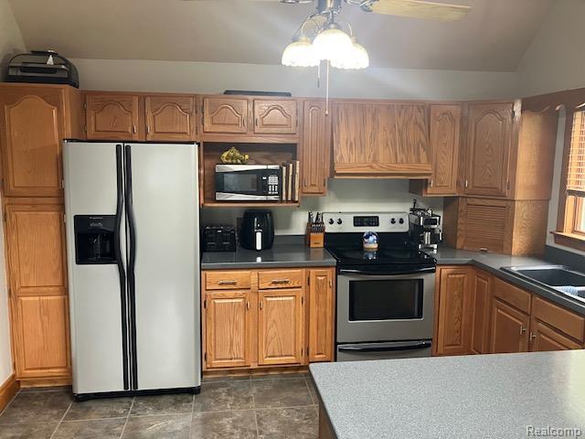 161 Fourth, Harbor Beach, MI 48441 - kitchen featuring appliances with stainless steel finishes, dark countertops, custom range hood, a sink, and brown cabinetry