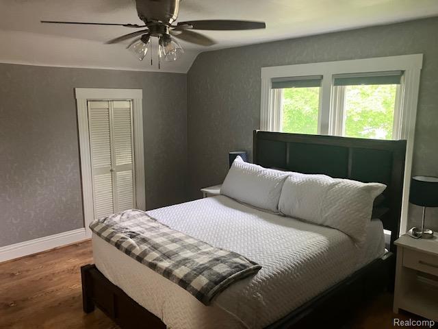 161 Fourth, Harbor Beach, MI 48441 - bedroom featuring wood finished floors, a closet, baseboards, ceiling fan, and vaulted ceiling