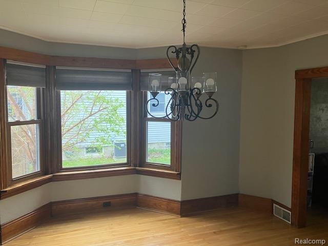 161 Fourth, Harbor Beach, MI 48441 - unfurnished dining area with a chandelier, light wood-style floors, healthy amount of natural light, baseboards, and crown molding