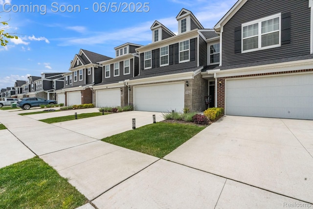 4782 Broomfield Way, Lake Orion, MI 48359 - townhome / multi-family property featuring a residential view, an attached garage, concrete driveway, brick siding, and stone siding