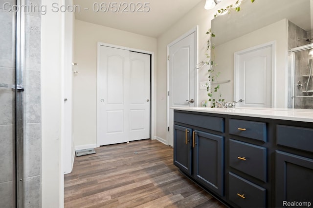 4782 Broomfield Way, Lake Orion, MI 48359 - full bathroom featuring wood finished floors, a stall shower, double vanity, and baseboards