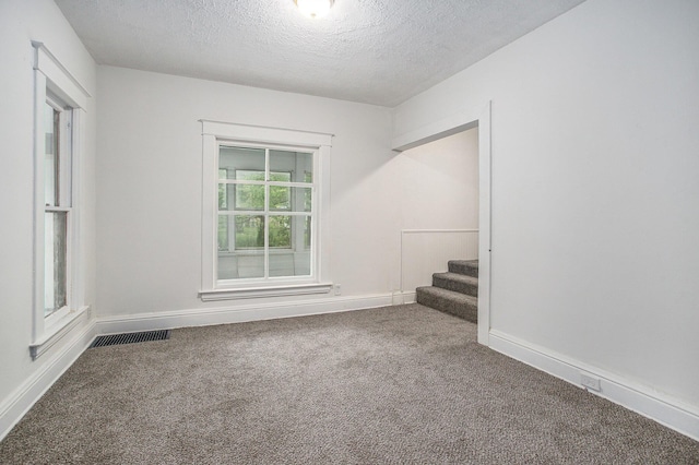 1702 Charles Ave, Kalamazoo, MI 49048 - carpeted spare room with a textured ceiling, stairs, and baseboards