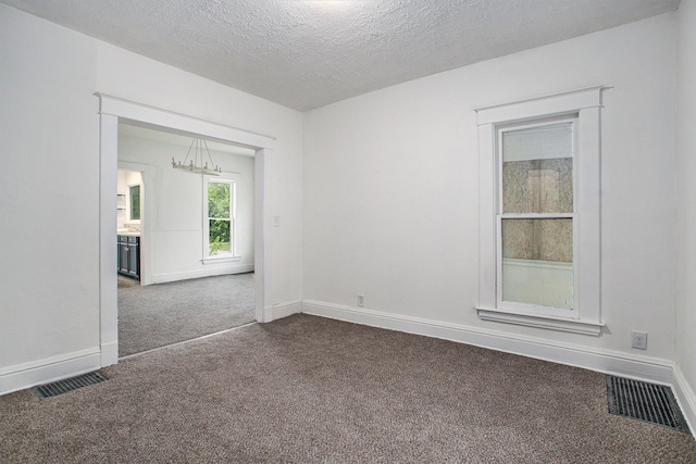1702 Charles Ave, Kalamazoo, MI 49048 - unfurnished room featuring dark carpet, a chandelier, baseboards, and a textured ceiling