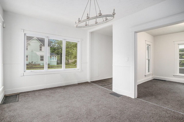 1702 Charles Ave, Kalamazoo, MI 49048 - unfurnished dining area featuring dark carpet, plenty of natural light, a chandelier, and baseboards