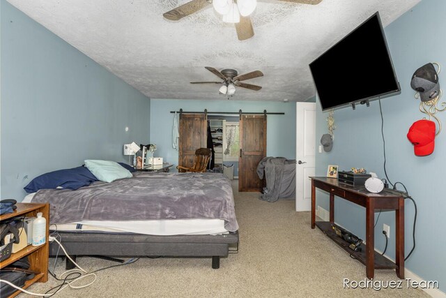 4160 Knapp Valley Dr NE, Grand Rapids, MI 49525 - bedroom featuring carpet floors, a barn door, a textured ceiling, and a ceiling fan