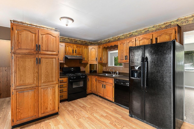 6900 Welch Lake Rd, Grass Lake, MI 49240 - kitchen featuring black appliances, under cabinet range hood, a sink, and brown cabinets