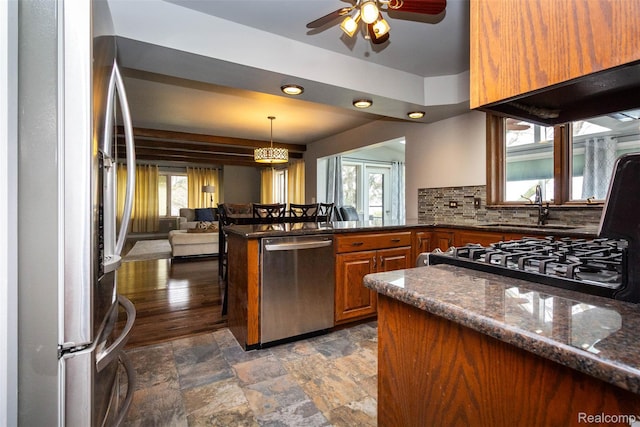 28220 Swan Island Dr, Grosse Ile, MI 48138 - kitchen with appliances with stainless steel finishes, a sink, a peninsula, brown cabinets, and ceiling fan