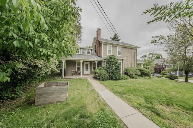 414 W Summit St, Ann Arbor, MI 48103 - back of house featuring covered porch, a lawn, and a chimney