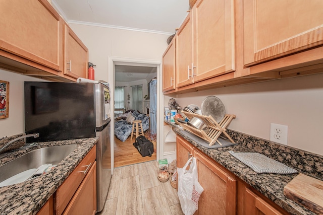 414 W Summit St, Ann Arbor, MI 48103 - kitchen featuring a sink, crown molding, freestanding refrigerator, dark stone counters, and light wood-style flooring