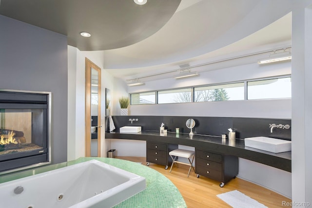 1363 Forest Bay Dr, Waterford, MI 48328 - bathroom featuring double vanity, wood finished floors, recessed lighting, a jetted tub, and a multi sided fireplace