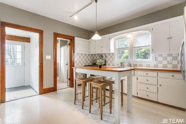 200 W 21st St, Holland, MI 49423 - kitchen with track lighting, light floors, white cabinetry, and healthy amount of natural light