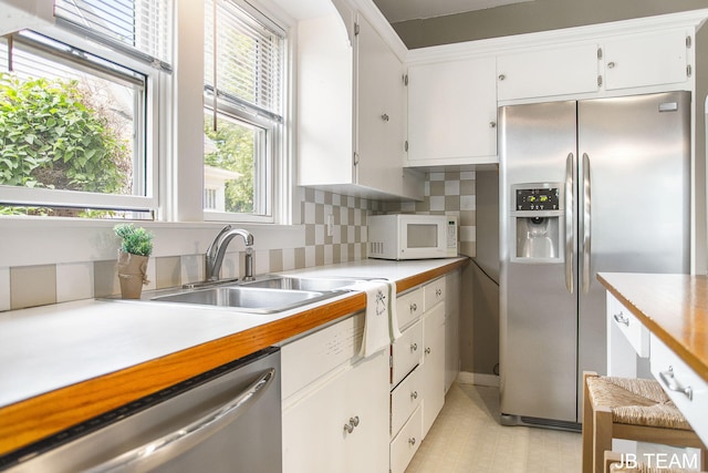 200 W 21st St, Holland, MI 49423 - kitchen with appliances with stainless steel finishes, a sink, white cabinetry, light countertops, and light floors