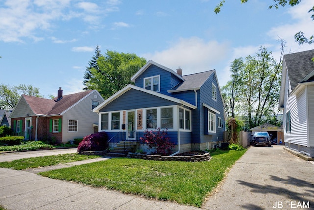 200 W 21st St, Holland, MI 49423 - bungalow-style house with a front yard, an outbuilding, a chimney, and driveway