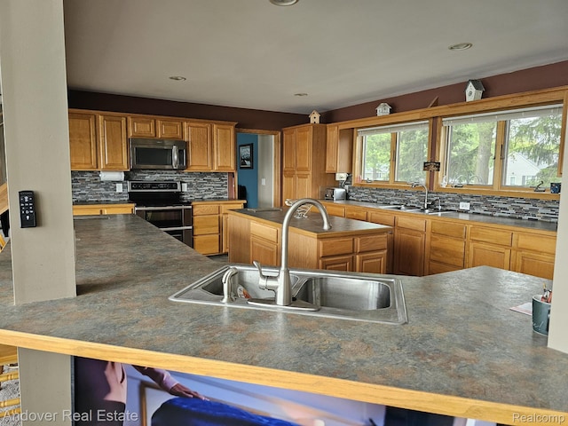 2501 Davista Dr, Highland, MI 48356 - kitchen with stainless steel appliances, a sink, tasteful backsplash, and a center island