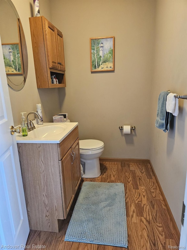 2501 Davista Dr, Highland, MI 48356 - half bath with vanity, toilet, and wood finished floors