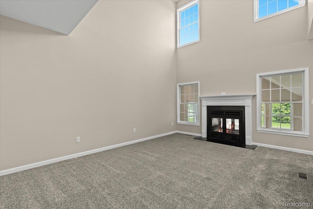 1132 Cantor Ln, South Lyon, MI 48178 - unfurnished living room with carpet flooring, baseboards, a high ceiling, and a multi sided fireplace