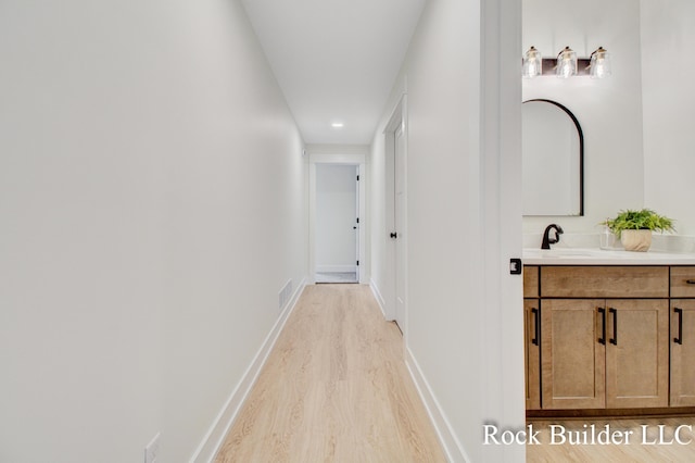 7134 Sugar Maple Dr, Hudsonville, MI 49426 - corridor with light wood-style flooring, baseboards, a sink, and recessed lighting