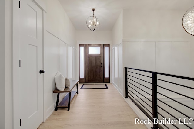 7134 Sugar Maple Dr, Hudsonville, MI 49426 - foyer entrance featuring a chandelier, light wood finished floors, and a decorative wall