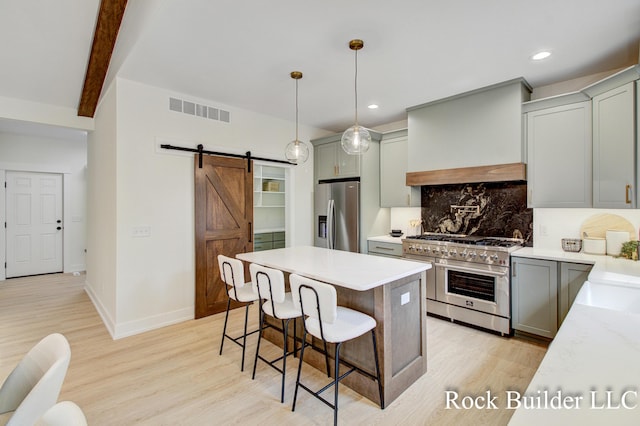 7134 Sugar Maple Dr, Hudsonville, MI 49426 - kitchen featuring appliances with stainless steel finishes, a barn door, decorative backsplash, light wood-type flooring, and gray cabinets
